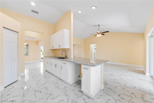 kitchen featuring light tile flooring, white cabinets, ceiling fan, and light stone counters