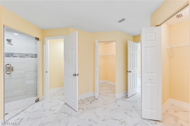 bathroom with a shower with door and tile flooring