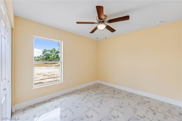 tiled empty room featuring ceiling fan