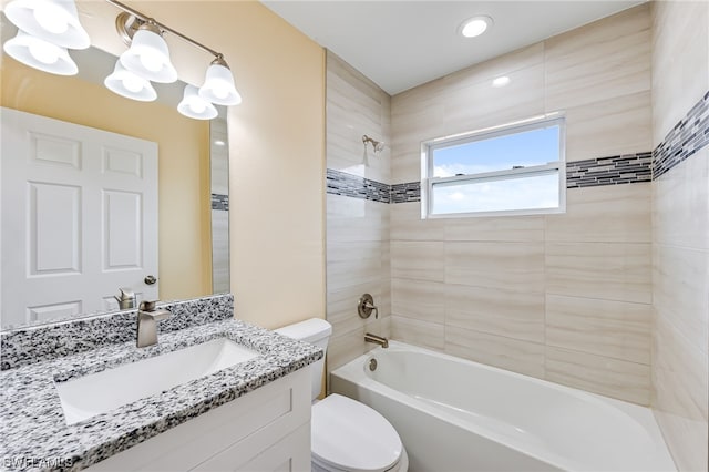 full bathroom featuring tiled shower / bath combo, toilet, and vanity