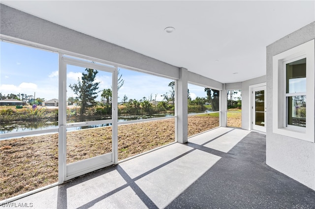 unfurnished sunroom with a water view