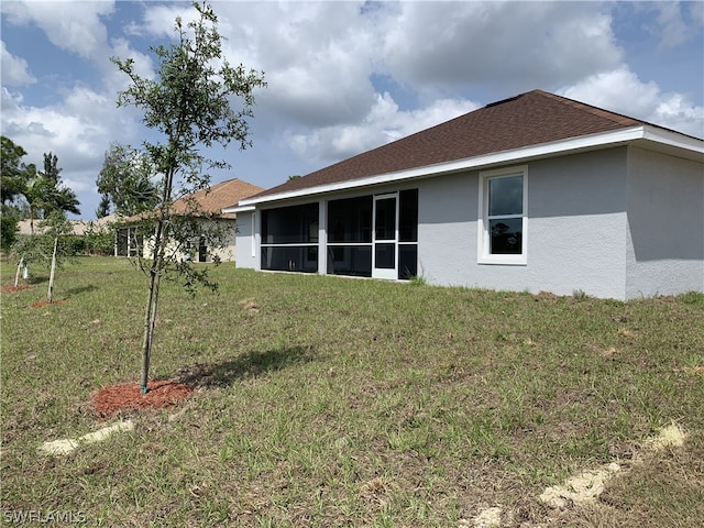 back of house with a sunroom and a yard