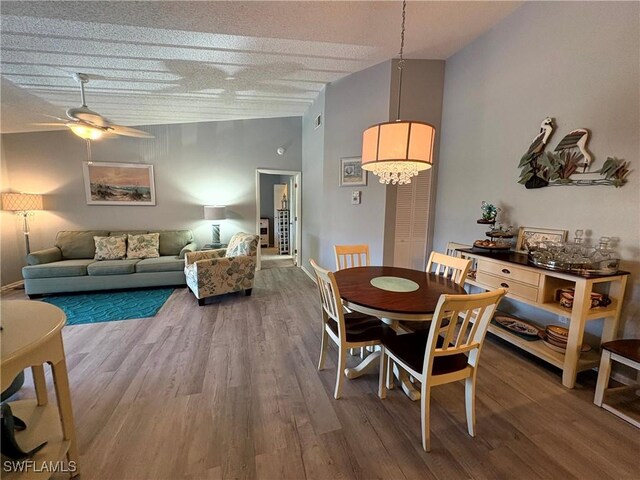 14861 Summerlin Woods Dr Unit 13, Fort Myers, FL 33919 - dining area featuring high vaulted ceiling, ceiling fan with notable chandelier, a textured ceiling, and wood finished floors