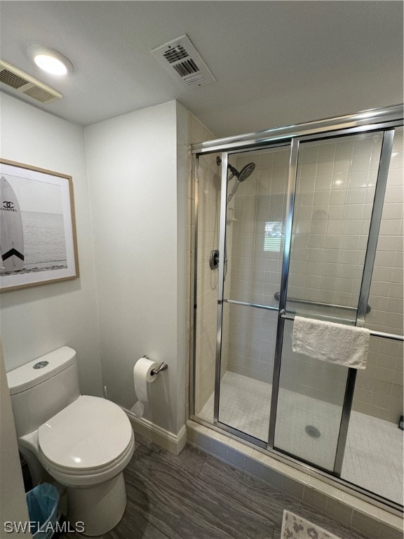 bathroom featuring an enclosed shower and toilet