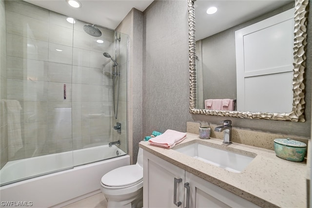 full bathroom featuring toilet, bath / shower combo with glass door, and vanity