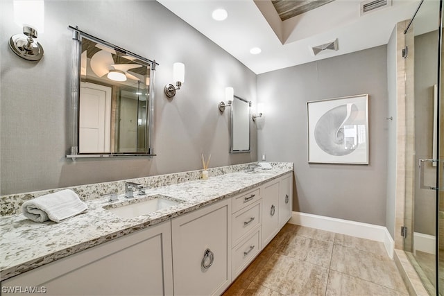 bathroom featuring double sink vanity, tile floors, and a shower with shower door