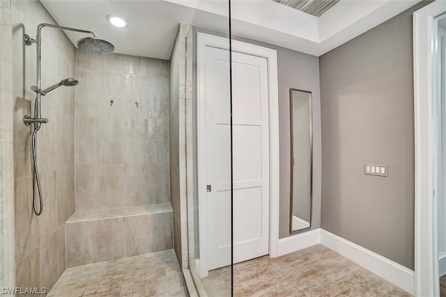 bathroom with tile floors and a tile shower