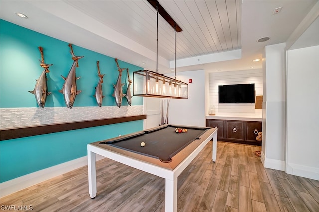 recreation room with pool table, a raised ceiling, and light hardwood / wood-style flooring