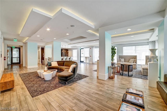 interior space with light hardwood / wood-style floors and a raised ceiling