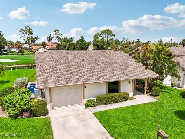 view of front facade with a water view, a garage, and a front lawn