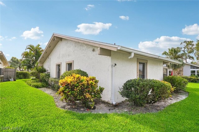 view of side of home with a lawn