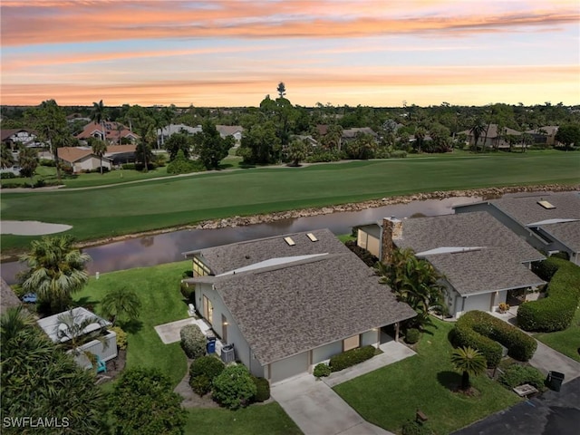 aerial view at dusk featuring a water view