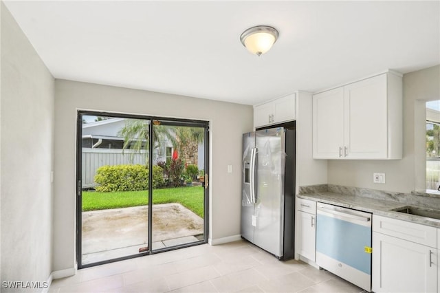 kitchen with white cabinetry, sink, light stone counters, and stainless steel appliances