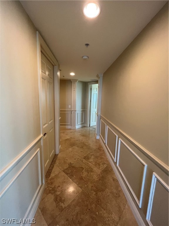 hallway featuring light tile floors and ornate columns