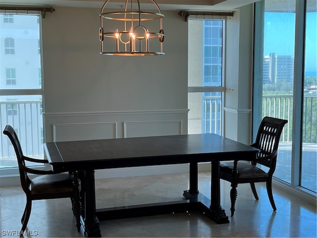 dining room featuring a chandelier and a wall of windows