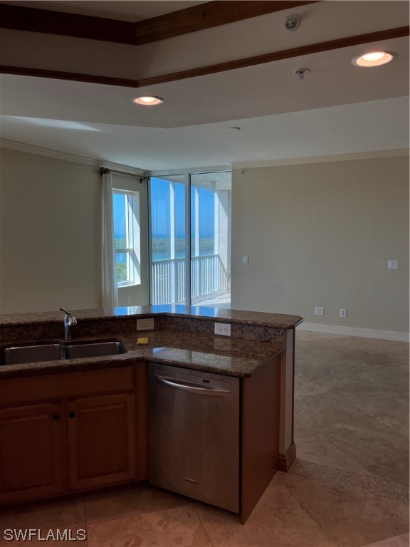 kitchen featuring sink, light tile floors, dark stone counters, stainless steel dishwasher, and ornamental molding