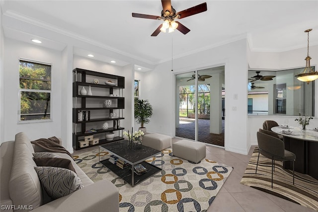 living room with ornamental molding, ceiling fan, and light tile floors