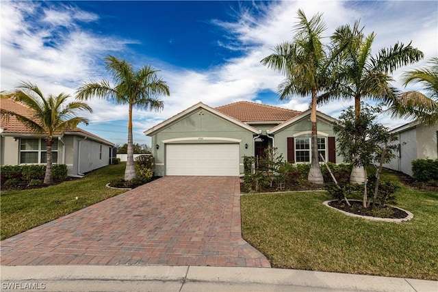 view of front of house with a front yard, decorative driveway, an attached garage, and stucco siding