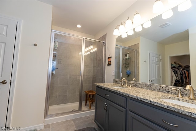 bathroom featuring tile flooring, walk in shower, oversized vanity, and dual sinks