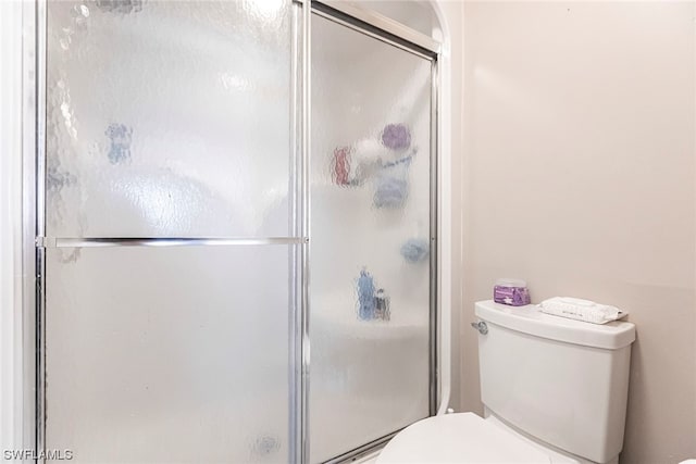 bathroom featuring walk in shower and toilet