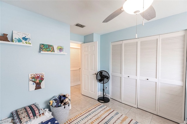 bedroom with ceiling fan, a closet, and light tile patterned flooring