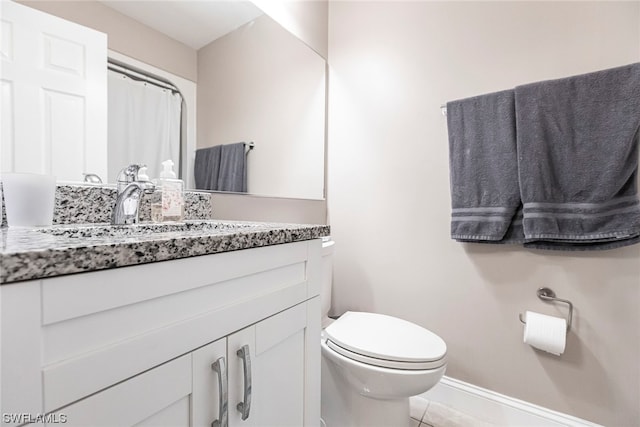 bathroom featuring tile patterned floors, vanity, and toilet