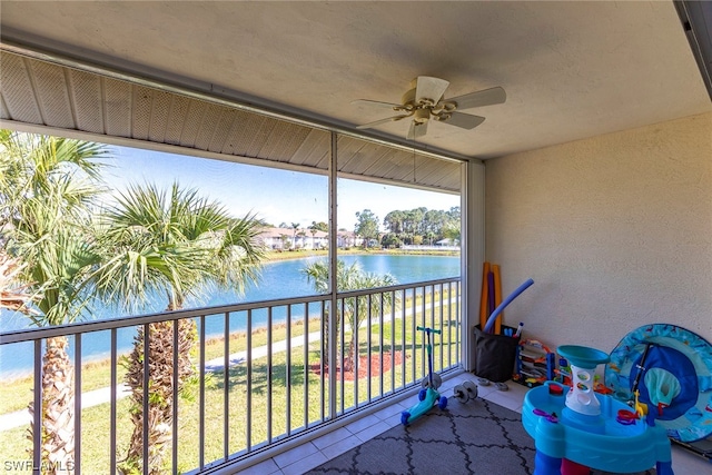 sunroom / solarium with ceiling fan and a water view