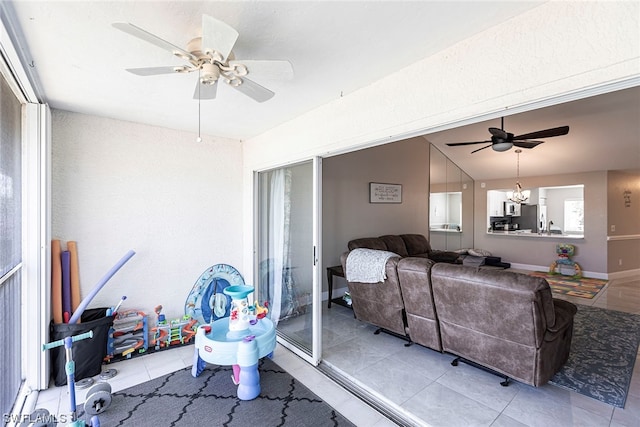 living room featuring ceiling fan with notable chandelier