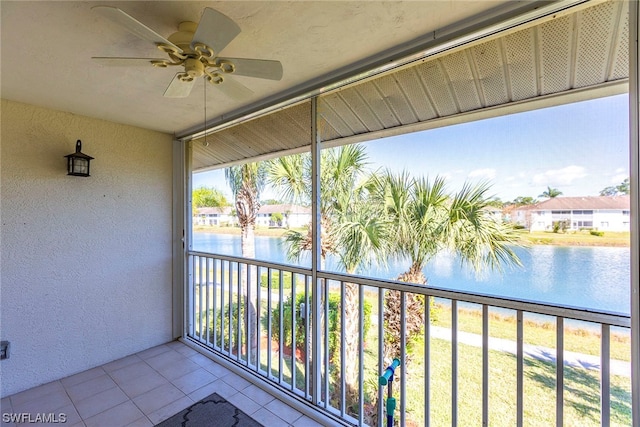 balcony with ceiling fan and a water view