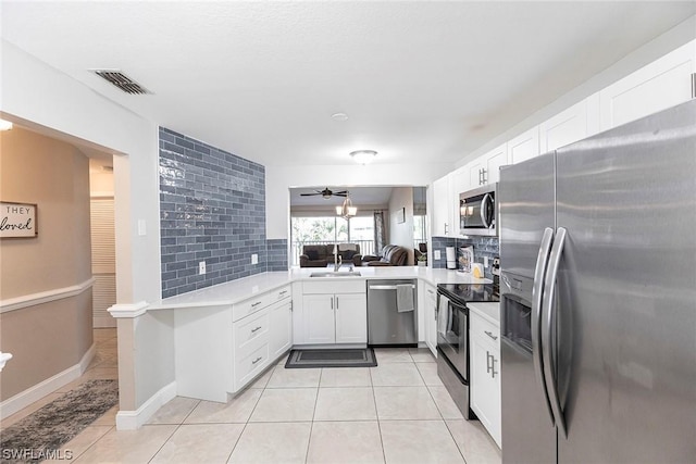 kitchen with sink, decorative backsplash, ceiling fan, kitchen peninsula, and stainless steel appliances