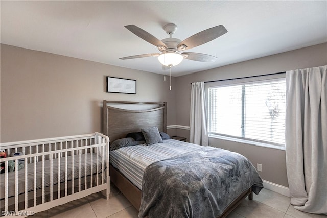 tiled bedroom featuring ceiling fan