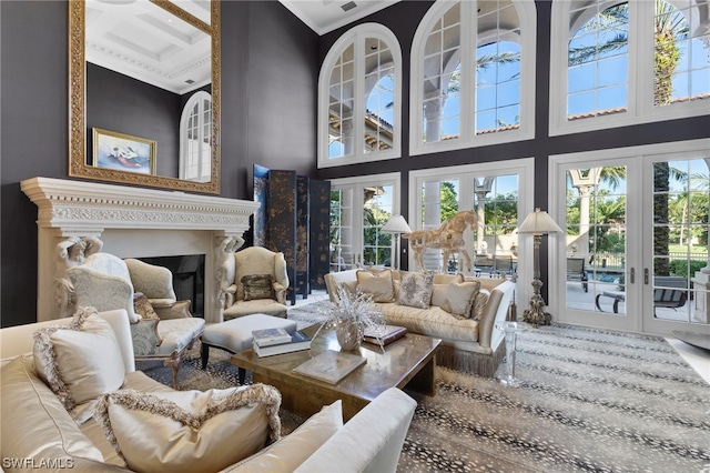 living room featuring beam ceiling, french doors, coffered ceiling, a towering ceiling, and ornamental molding