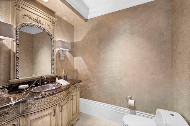 bathroom with toilet, vanity, and ornamental molding