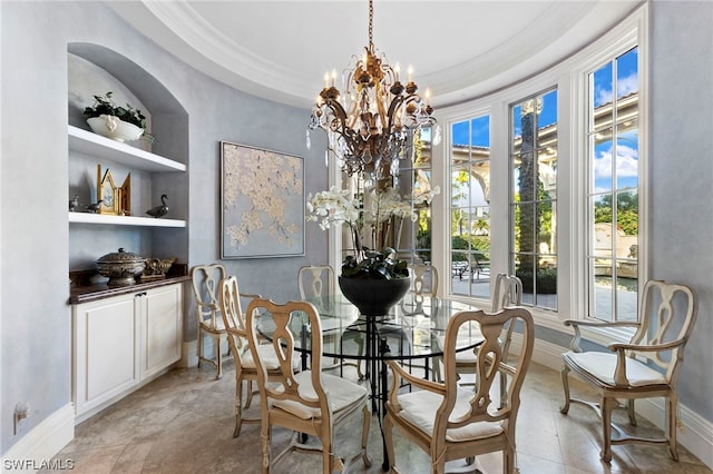 dining area featuring a chandelier, built in shelves, a raised ceiling, and ornamental molding