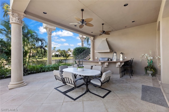 view of patio / terrace with exterior kitchen, ceiling fan, and a bar