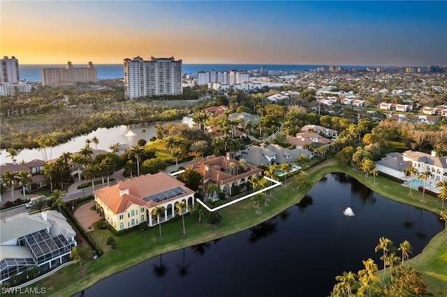 aerial view at dusk featuring a water view