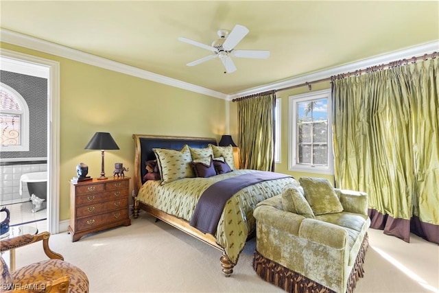 bedroom featuring carpet flooring, ensuite bath, ceiling fan, and crown molding