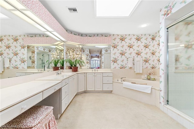 bathroom featuring vanity, a skylight, and separate shower and tub