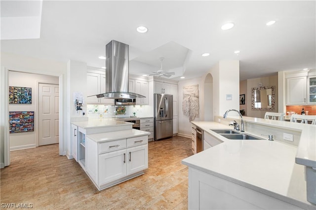 kitchen featuring white cabinets, stainless steel appliances, sink, island range hood, and ceiling fan