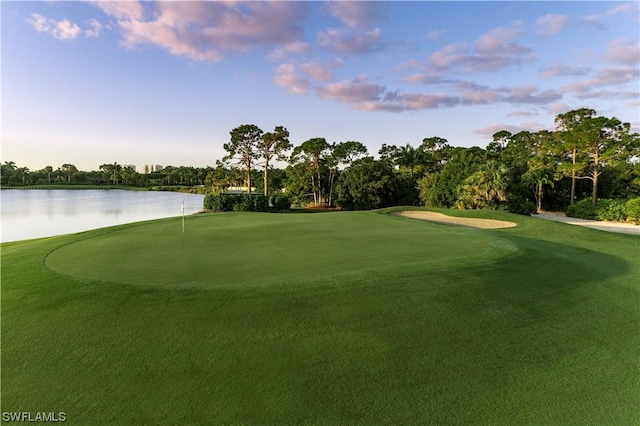 surrounding community featuring a lawn and a water view