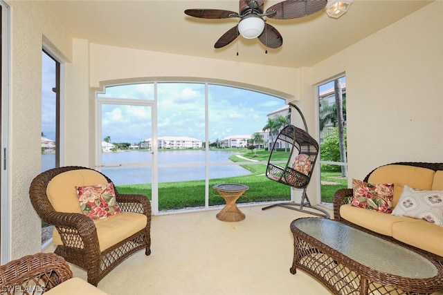 sunroom / solarium featuring a water view and ceiling fan