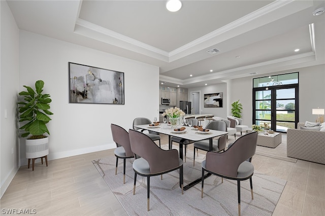 dining room featuring french doors, crown molding, and a raised ceiling