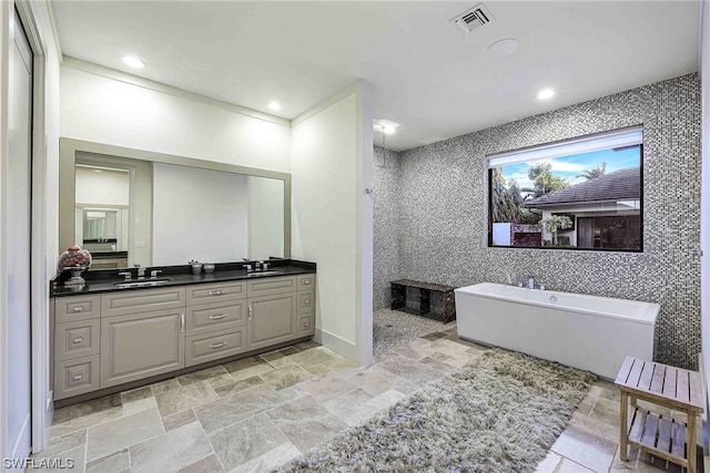 bathroom featuring double sink vanity, tile floors, and a bath to relax in