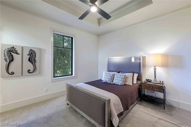 bedroom featuring a raised ceiling, light carpet, and ceiling fan