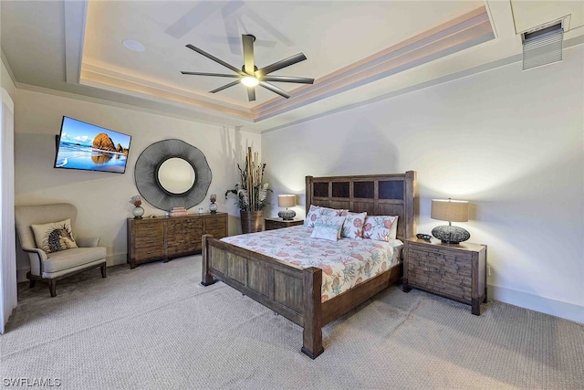 bedroom featuring light colored carpet, a raised ceiling, and ceiling fan