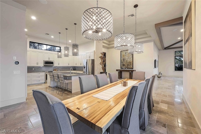 tiled dining room featuring a notable chandelier and sink