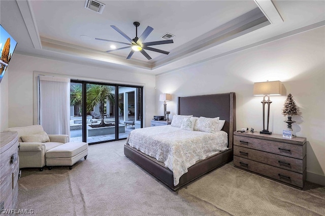 bedroom with a raised ceiling, light colored carpet, ceiling fan, and access to outside