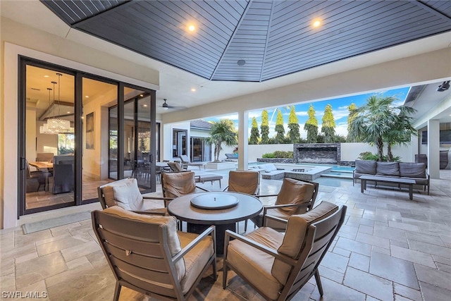 view of terrace featuring outdoor lounge area, ceiling fan, and an outdoor hot tub