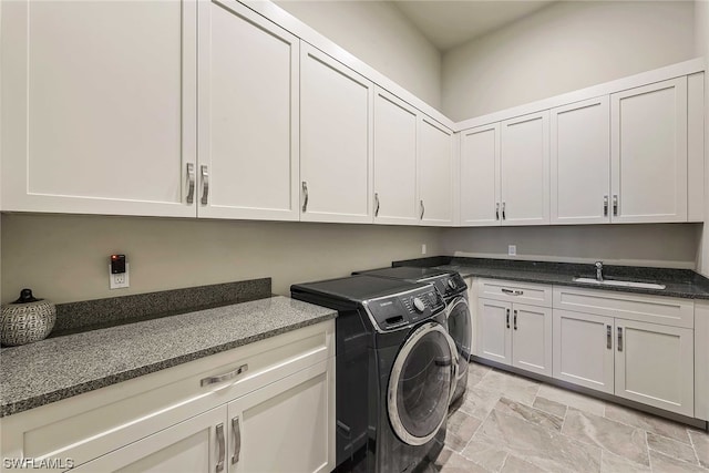 laundry area featuring sink, washer and clothes dryer, cabinets, and light tile flooring