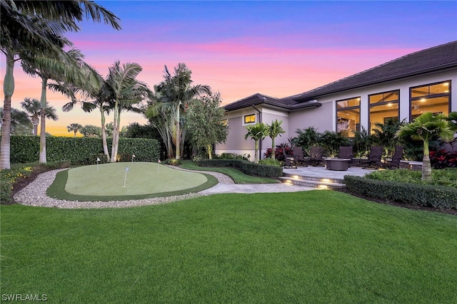 yard at dusk featuring a patio area